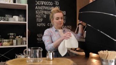 genç kadın barista yemek hazırlama, cam dükkanda kahve makinesi ile kahve yapmadan önce