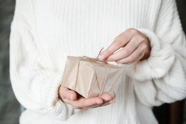 白いニットのセーターを着た女性が包まれた贈り物を与える クリスマスボックスプレゼントを持つ女性の手をクローズアップ クリスマス 買い物 冬休みの準備 寄付の概念 — ストック写真