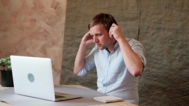 Dizüstü klavyede yazan, kulaklıkla müzik dinleyen ve dans eden adam. İşyerinde kulaklık takan mutlu bir işadamı. Serbest, birlikte çalışma, iş, ofis, komik, şaka.