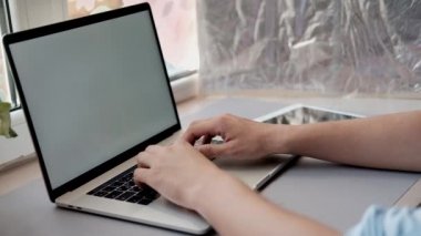 Ofis masasında oturan, dizüstü klavyeye el yazan ve başparmaklarını gösteren adam. Erkek elleri Kapat. Serbest çalışma, iş, başarı. Alay etmek 