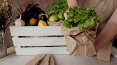 Sebze dükkanında Geri Dönüşümlü Kağıt torba. Kadın satıcı çevre dostu kağıt torbalara yiyecek koyuyor. Eko alışveriş, tüketim, sıfır atık, plastik yok 