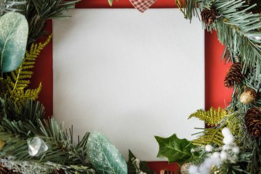 Noel dekorasyonu ile kırmızı arka plan üzerinde beyaz poster mockup . Tasarım için Boş Tuval Mockup. Noel, Yeni Yıl, alışveriş, Tatil hazırlık, satış, konsept.
