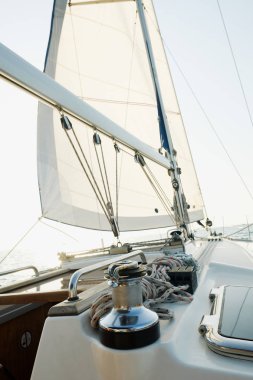 Okyanusta yat. Açık denizde beyaz yelkenli yelkenli yelkenli gemi. Yat güvertesinden direğe ve yelkene kadar manzara. Spor, tatil, seyahat, yaz, aktivite konsepti 