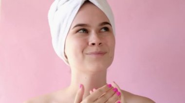Genç kadın kozmetik nemlendirici yüz kremi sürüyor. Yüz spa güzellik tedavisi, cilt bakımı, kozmetoloji. Kapat.