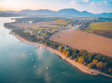 Aerial view of Liptovska Mara lake with the Tatra Mountains in the background.  Autumn sunset. clipart