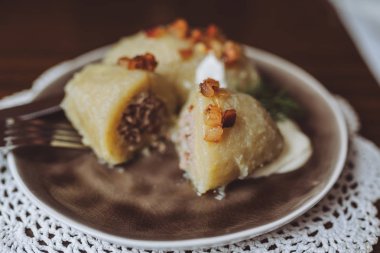 Doldurulmuş patates köfte (cepelinai) geleneksel Litvanyalı tabak. Köfte rendelenmiş ve riced patatesten yapılır ve kıyma veya kuru lor peyniri veya mantar dolması