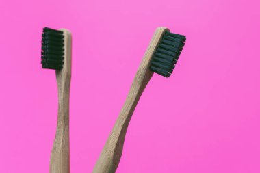 Pembe arka plan izole iki bambu diş fırçaları