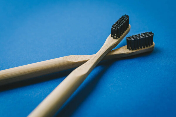 Two bamboo toothbrushes isolated on blue background