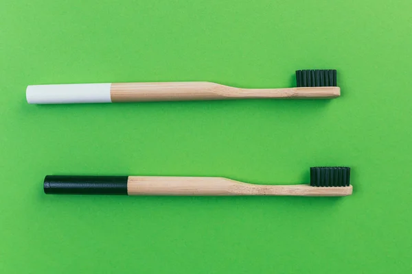 Duas Escovas Dentes Bambu Isoladas Fundo Verde — Fotografia de Stock