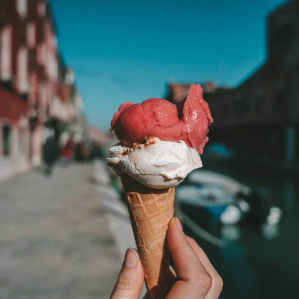 伝統的なイタリアのアイスクリームを保持 ワッフル コーンのジェラートが呼び出されます バック グラウンドでヴェネツィア ムラーノ島 — ストック写真