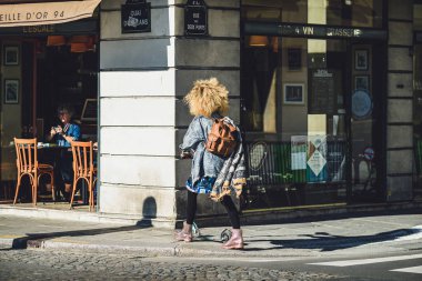 İnsanlar güneşli bir sonbahar gününde şehirde vakit geçiriyorlar.