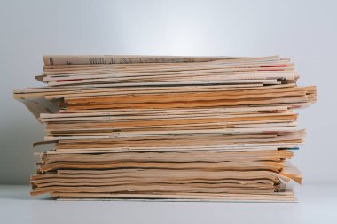Beyaz arkaplanda izole edilmiş eski gazete yığını