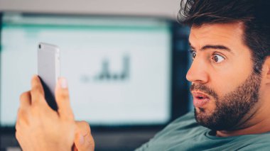 Şaşırmış genç adam Smartphone vasıl el arıyorum