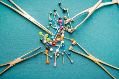 Vücut piercing takı halkaları, renkli arka plan üzerinde delinme implantlar