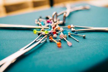 Vücut piercing takı halkaları, renkli arka plan üzerinde delinme implantlar