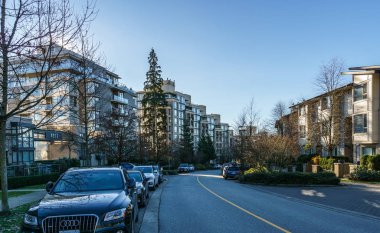 Burnaby, Kanada - 17 Kasım 2019: British Columbia'da güneşli sonbahar gününde apartmanlar ve sokak manzarası.
