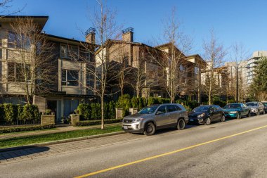 Burnaby, Kanada - 17 Kasım 2019: British Columbia'da güneşli sonbahar gününde apartmanlar ve sokak manzarası.