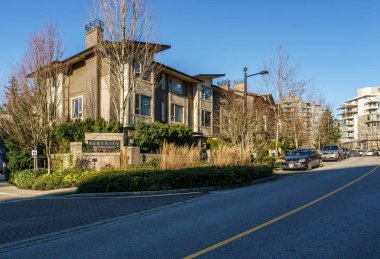 Burnaby, Kanada - 17 Kasım 2019: British Columbia'da güneşli sonbahar gününde apartmanlar ve sokak manzarası.