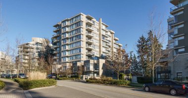 Burnaby, Kanada - 17 Kasım 2019: British Columbia'da güneşli sonbahar gününde apartmanlar ve sokak manzarası.