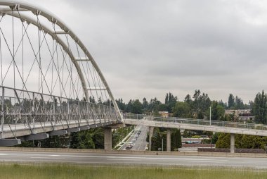 ABBOTSFORD, CANADA - MAY 29, 2019: pedestrian and bicycle bridge over the highway. clipart