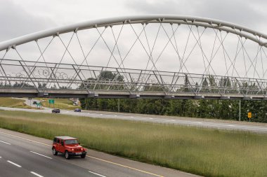 ABBOTSFORD, CANADA - MAY 29, 2019: pedestrian and bicycle bridge over the highway. clipart