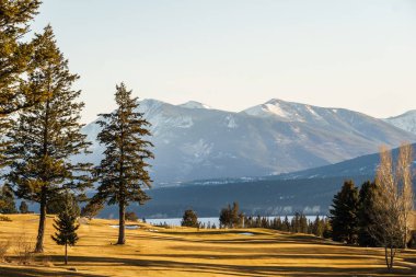 Fairmont Hot Springs, Kanada - 22 Mart 2019: Küçük kasabalarda golf sahası güneşli öğleden sonra kayalık dağlarda.