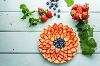 Çilek ile Kek Mavi rustik masada çilek ve yaban mersini ile Pasta.