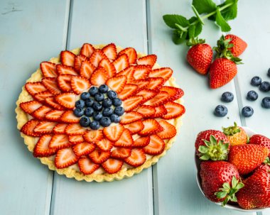 Çilek ile Kek Mavi rustik masada çilek ve yaban mersini ile Pasta.