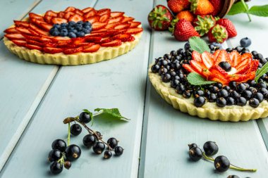 Çilek pasta ile kek çilek ve mavi rustik masada siyah kuş üzümü ile Pasta.