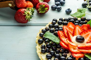 Çilek pasta ile kek çilek ve mavi rustik masada siyah kuş üzümü ile Pasta.
