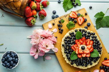 Çilek pasta ile kek çilek ve mavi rustik masada siyah kuş üzümü ile Pasta.