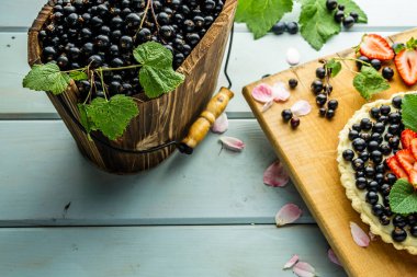 Çilek pasta ile kek çilek ve mavi rustik masada siyah kuş üzümü ile Pasta.