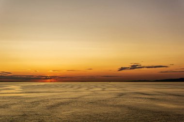 Vancouver ve Victoria arasında Gürcistan boğazında bulutlu gün batımı ve ay.