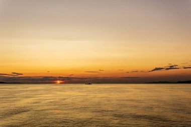 Vancouver ve Victoria arasında Gürcistan boğazında bulutlu gün batımı ve ay.