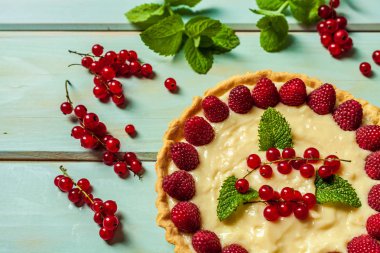 ahşap arka planda yaz tatlısı olarak taze çilek ile frenk üzümü pasta.
