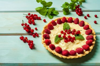ahşap arka planda yaz tatlısı olarak taze çilek ile frenk üzümü pasta.