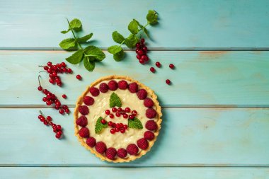 ahşap arka planda yaz tatlısı olarak taze çilek ile frenk üzümü pasta.