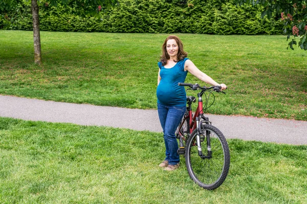 Schwangere Auf Dem Grünen Rasen Einem Park Mit Fahrbereitem Fahrrad — Stockfoto