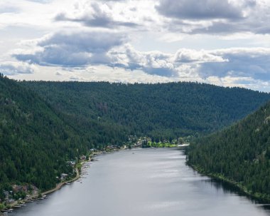 Tepeden Paul Gölü 'ne Yeşil dağlar ve beyaz bulutlar İngiliz Kolombiyası Kanada.
