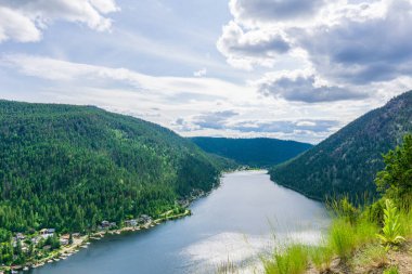 Tepeden Paul Gölü 'ne Yeşil dağlar ve beyaz bulutlar İngiliz Kolombiyası Kanada
