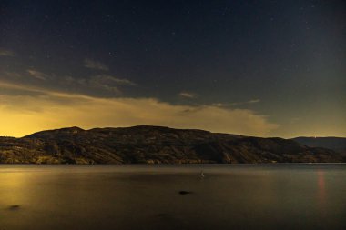 Yıldızlı gökyüzü Okanagan Gölü kıyısında geceleyin görüldü Britanya Kolombiyası Kanada.