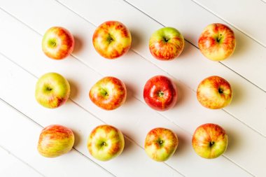 Beyaz ahşap arka planda taze elmalar.