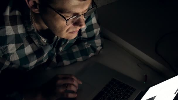 メガネの男は、夜遅くまで働きます。心配だね、彼を見て彼は、クローズ アップの前にコンピューターの画面に — ストック動画