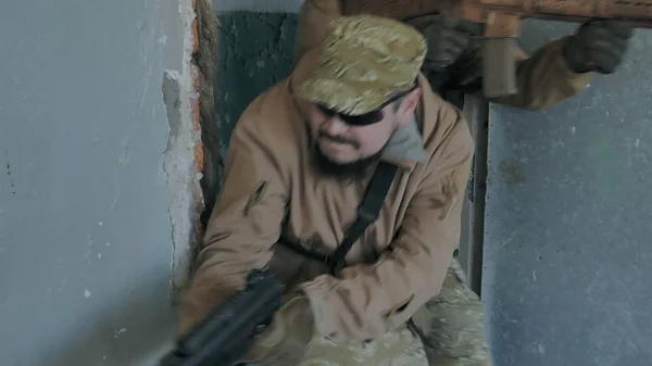 Soldaten in Tarnkleidung mit militärischen Waffen klopfen an die Tür und besetzen das alte Gebäude, das militärische Konzept — Stockfoto