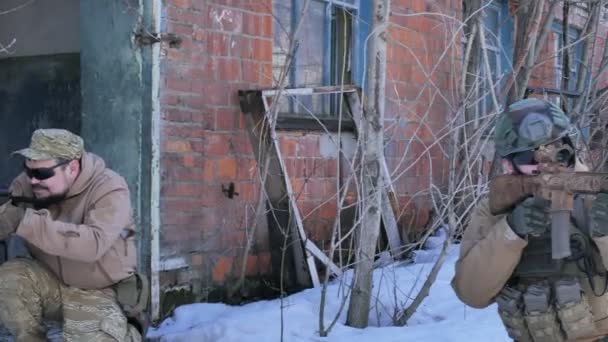 Des soldats camouflés avec des armes de combat sortent de l'ancien bâtiment, dans le but de le capturer, le concept militaire — Video