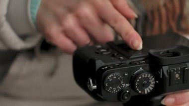 Kırmızı bir şapka giyen sportif sıcak giysiler ve Silindirler, ahşap Bank ve vintage fotoğraf makinelerinde fotoğraf çekimi oturan genç güzel kadın