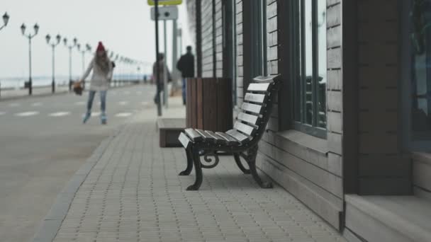 Ung vacker kvinna i en röd hatt, bär sportig varma kläder och valsar, ridning på vägen på kusten — Stockvideo