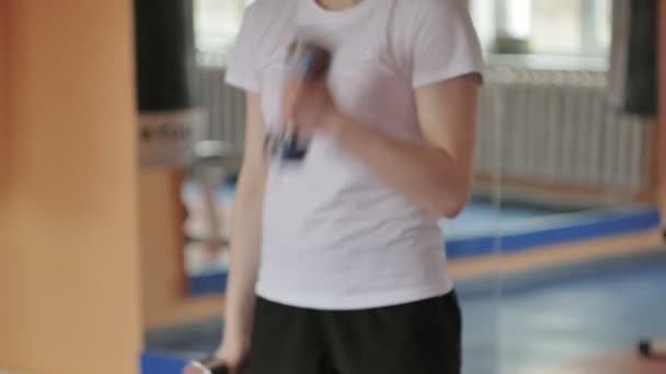 Vrouw kickbokser is opleiding in een sportstudio met halters — Stockvideo