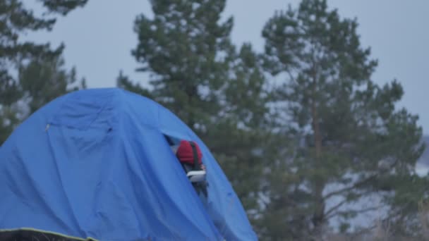 Attraente giovane donna turista con un cappello rosso si siede in una tenda turistica e gode di un casco realtà virtuale — Video Stock