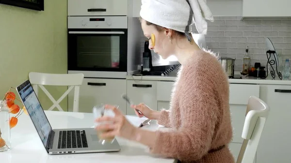 Aantrekkelijke zakenvrouw cosmetische gezichts plekken thuis, toe te passen op die zijn werken achter een laptop — Stockfoto